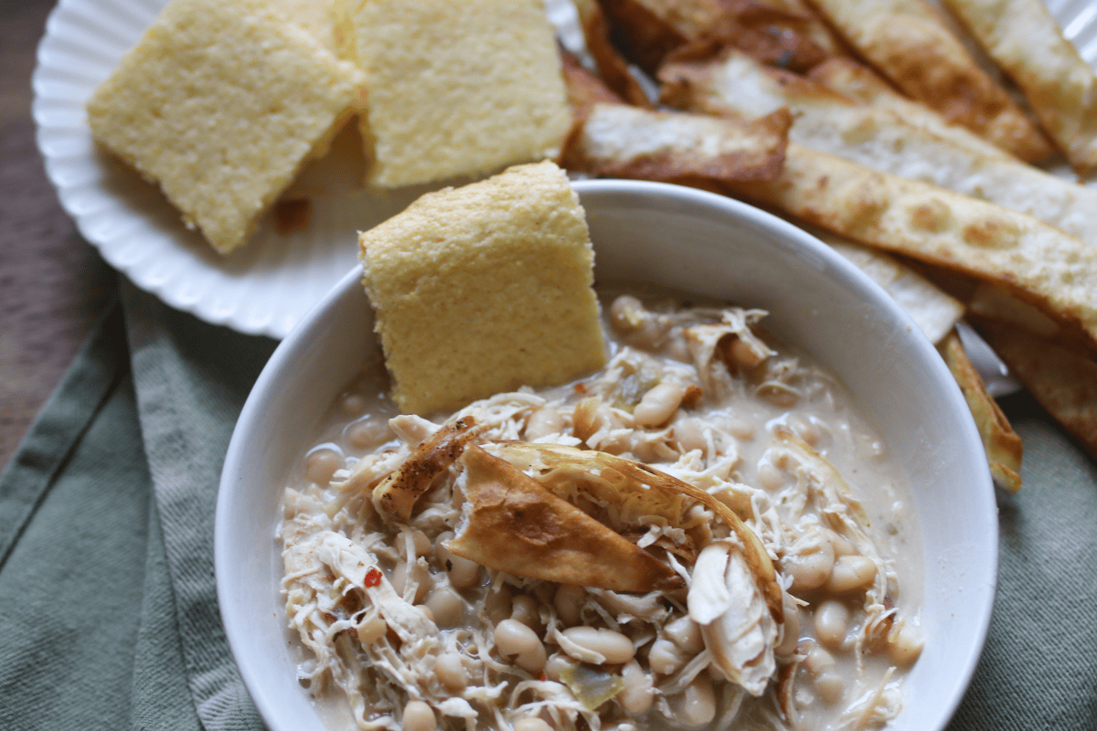 White chicken chili topped with homemade tortilla strips and fresh garnishes